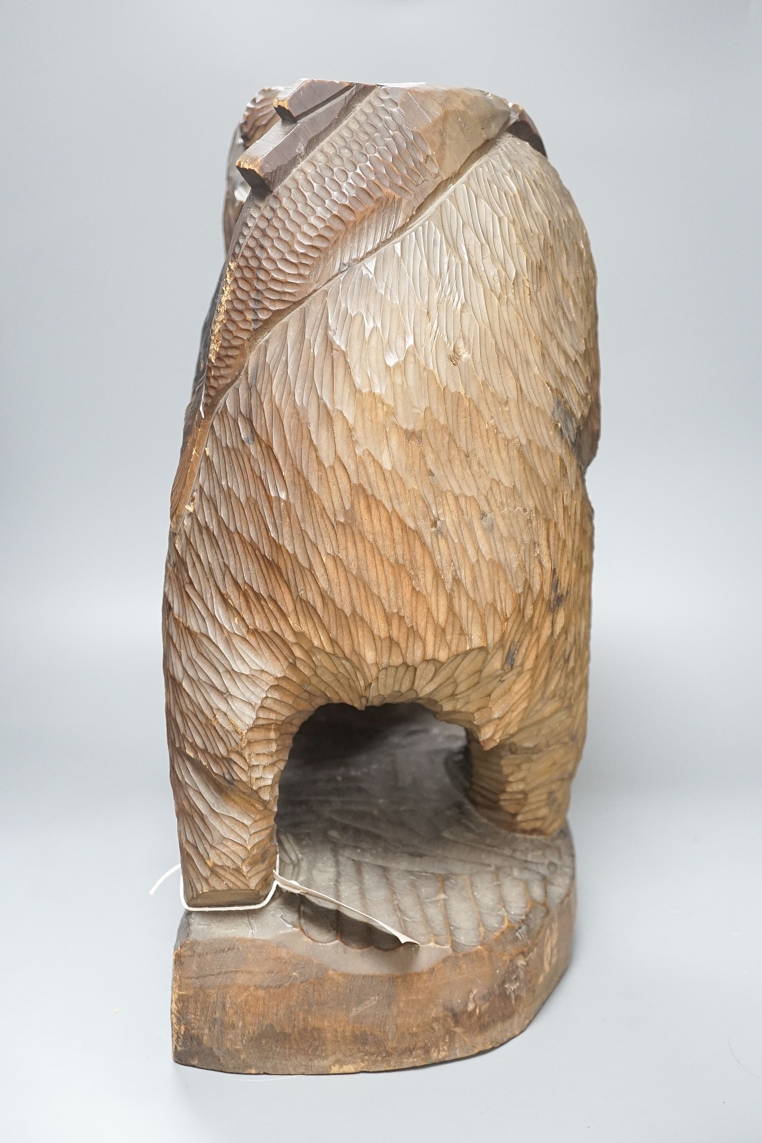 A large Japanese carved wooden bear holding a fish, inscribed 47cm
